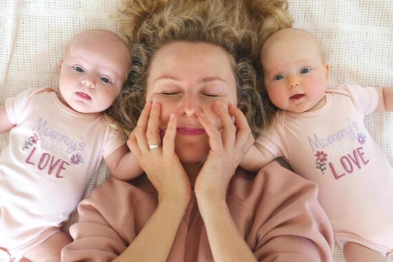 mom lying between twin babies